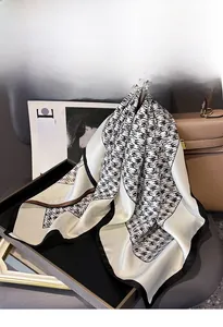 Detail of silk twill scarf with abstract pattern and heart-shaped rhinestone brooch