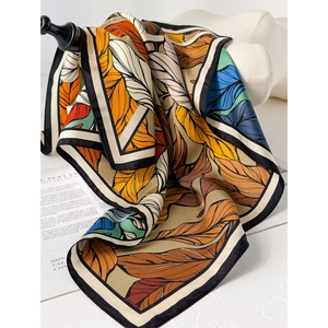 Silk twill square scarf with vibrant leaf prints and black borders on fashion magazine