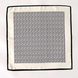 Classic silk-textured scarf featuring black houndstooth pattern and ivory border
