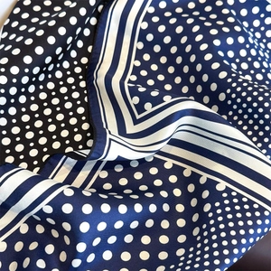 Gros plan du foulard en soie avec des pois et des rayures blanches élégantes sur le bord