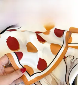 Detailed close-up of fine triangular needle stitching on a silk tulip print scarf