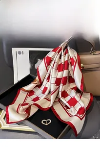 Close-up of silk twill scarf with red checkered pattern and heart diamond buckle