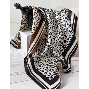 Classic leopard and stripe silk scarf draped on a display stand for elegant styling