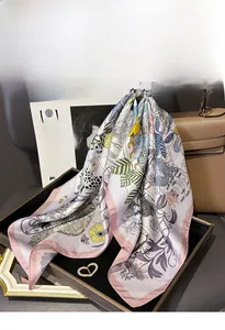 Detail of silk twill scarf with leopard and floral prints next to a stylish handbag