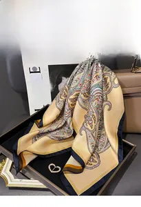 Detailaufnahme von Seiden-Twill-Schal mit Paisley-Muster und goldenen Farbtönen