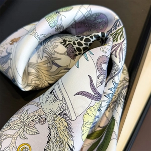 Macro detail of twill silk scarf showing artistic floral and butterfly illustrations