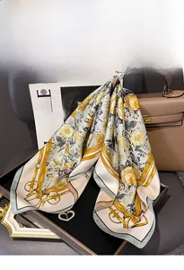 Detailed texture of silk twill square scarf featuring yellow floral and golden ribbon patterns
