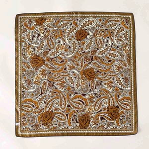 Caramel silk square scarf with paisley and rose patterns flat laid on white background