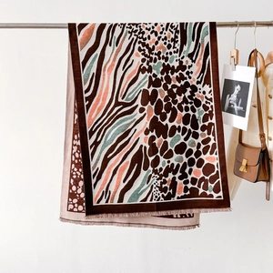 Detail of leopard and zebra print scarf featuring orange accents and fringe edges