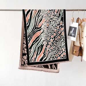 Detail of leopard and zebra pattern thick cashmere-like scarf with fringe edges