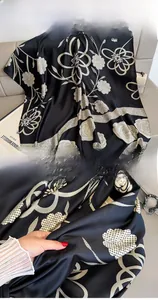 Close-up of camellia print silk scarf featuring premium machine-stitched edge craftsmanship