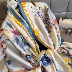 Elegante chal de seda con motivos florales y bordes azules con caída delicada