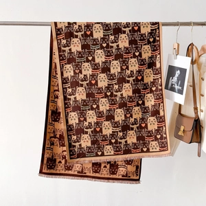 Détail d'une écharpe marron chaud avec motifs de chats mignons et bords à franges fins