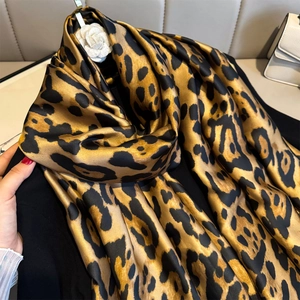 Écharpe en soie léopard d'été avec broche camélia sur fond noir pour un style chic