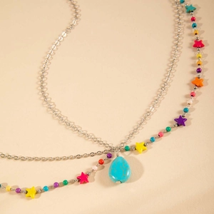 Détail macro de la chaîne de cheveux bohème argentée avec perles étoiles et turquoise