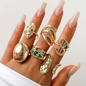 Makroaufnahme von 6-teiligem Goldring-Set mit Perlen und grünen Smaragd-Akzenten im Set