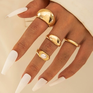 Nahaufnahme von vergoldetem Ring-Set mit Vintage-Textur und ovaler weißer Perleneinlage