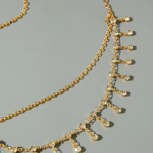 Vue détaillée de la chaîne de tête mauvais œil dorée avec strass pendants et franges