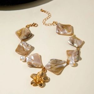 Macro detail of ocean-style bracelet with golden flower charm and iridescent shell tiles