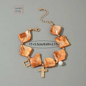 Detail of orange bohemian beaded bracelet with gold cross and pearl charms
