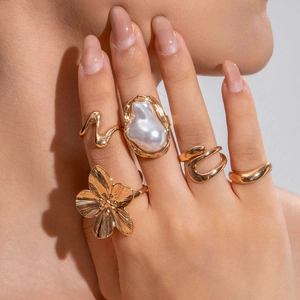 Nahaufnahme von Goldblumenring und Barockperlenring aus einem Vintage-Fünfer-Set