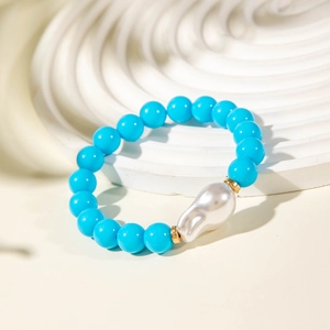 Detail of blue beaded bracelet featuring a large baroque pearl and golden spacers