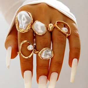 Detailansicht geschichteter Boho-Goldringe mit Barockperlen an den Fingern eines Models