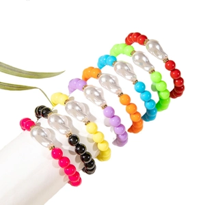 Rainbow beaded bracelet set with baroque pearls and gold spacers on white stand