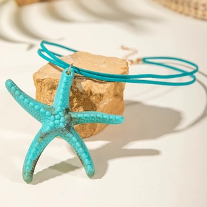 Detail eines blauen Seesternanhängers an einer Velourskordel mit Metallkette