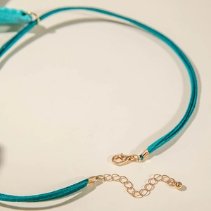 Detail eines blaugrünen Chokers mit vergoldetem Karabinerverschluss und verstellbarer Kette