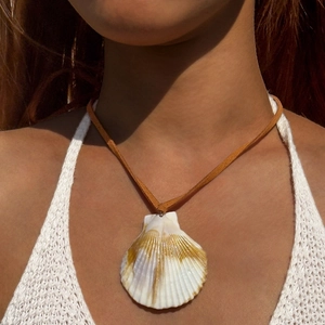 Böhmische Muschelhalskette mit braunem Wildlederband auf weißem Häkeloberteil für Strand