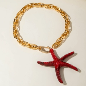 Vue détaillée du collier à chaîne dorée avec un pendentif étoile de mer rouge texturé
