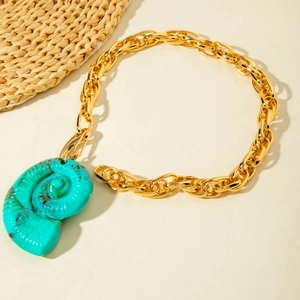 Détail du pendentif nautile turquoise sur grosse chaîne dorée pour vacances à la plage