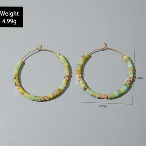 Détail de boucles d'oreilles créoles perlées vertes avec dimensions de 5,3 cm de hauteur