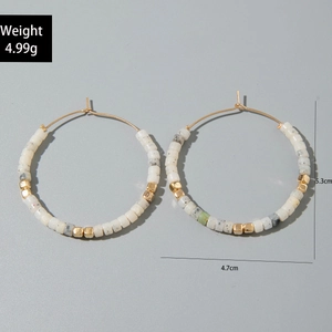 Détail de créoles de style français avec perles en résine et accents dorés, hauteur 5,3 cm