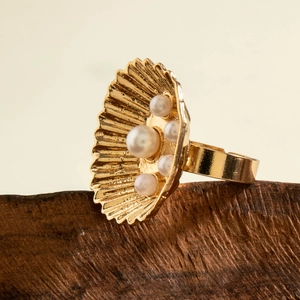 Detailed view of adjustable golden shell ring featuring five radiant white pearls