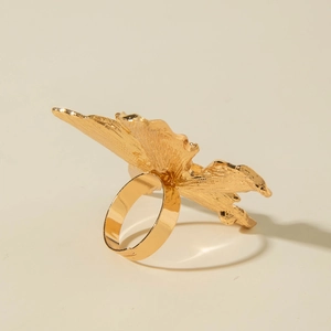 Detail of golden adjustable flower ring featuring brushed metal textures and wavy petals