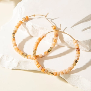 Boucles d'oreilles créoles rétro en métal doré avec perles en résine orange sur décor