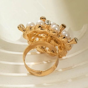 Detailed view of adjustable golden flower ring with white pearls and vintage textures