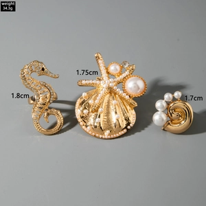 Detailed view of gold ocean theme rings with seahorse, starfish and pearl embellishments