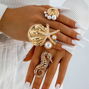 Detailed view of ocean-themed gold rings with Baroque pearl, seahorse, and starfish motifs