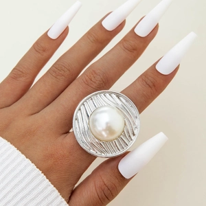 Adjustable silver spiral ring featuring a large white pearl and irregular floral engraving