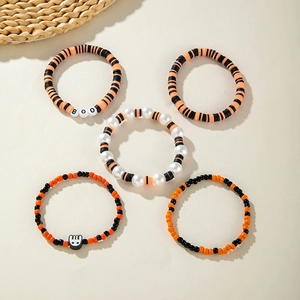 Halloween stackable stretch bracelets with orange and black heishi beads and Boo charms