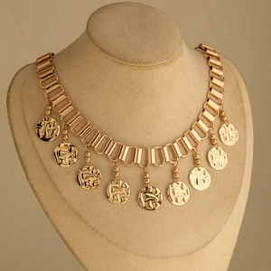 Collier bohème à gros maillons dorés avec pendentifs pièces texturées sur un buste