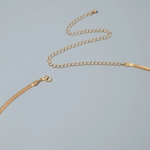 Dettaglio di una catena a serpente dorata con chiusura a moschettone e prolunga
