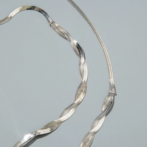 Dettaglio macro della catena a serpente argento con paillettes e trame intrecciate