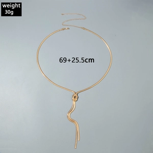 Dettaglio catena in vita a serpente dorata con design a nodo e nappine metalliche