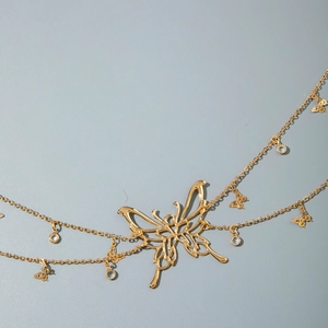 Close-up of gold butterfly waist chain with multi-layer metal links and crystal charms