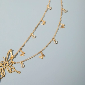 Detail of gold butterfly waist chain featuring delicate metal charms and clear crystals