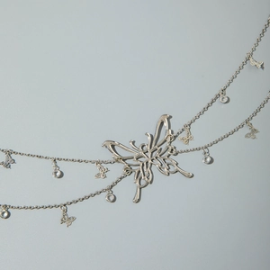 Detailed close-up of double-layered silver waist chain with butterfly pendants and rhinestones